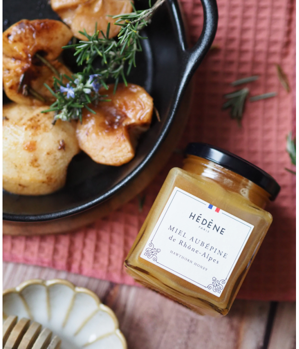 Glas med Hédéne Hidtjørn honning, Miel Aurepine de Rhone-Alpes, på bord med en skål med bagte æbler, Frankrig