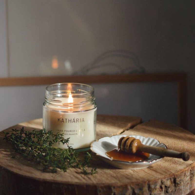 Duftlys i glas med en tallerken med honningske med honning på en tallerken